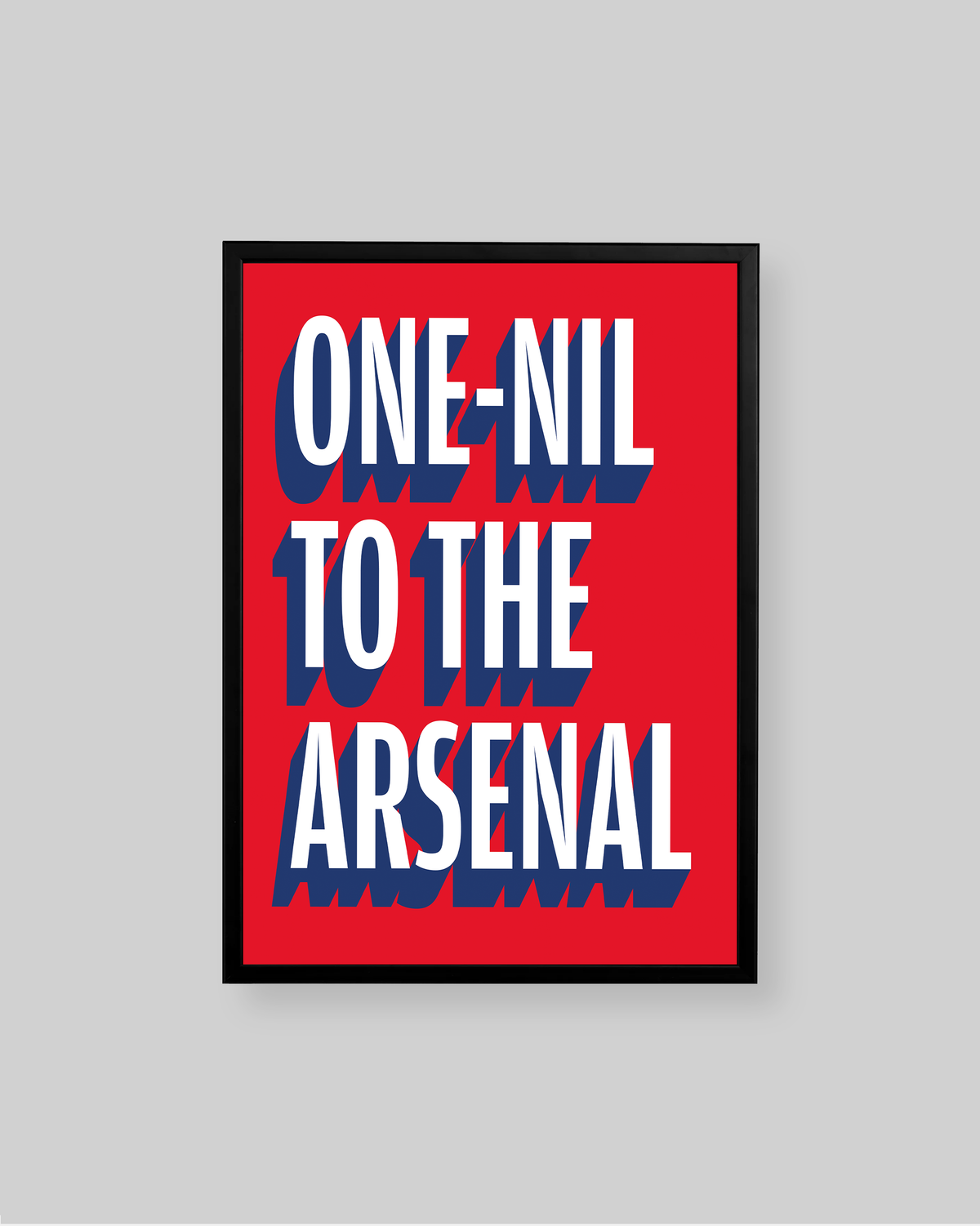 A framed typographic wall art print with the text 'ONE-NIL TO THE ARSENAL' in large white letters with blue drop shadows on a bright red background, shown against a light gray wall.