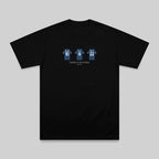 A black short-sleeve crewneck t-shirt with a graphic on the chest showing three blue and white striped hockey players wearing numbers 16, 18, and 22, with the text 'THREE WINNERS' and 'Vancouver' below it, displayed on a neutral gray background.