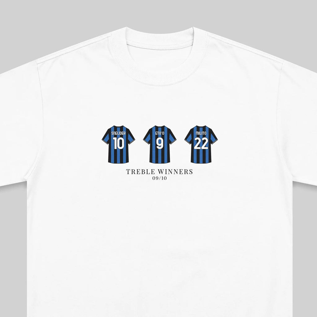 A white crewneck t-shirt featuring a graphic print of three blue and black striped soccer jerseys with the numbers 10, 9, and 22, and the text 'TREBLE WINNERS 09/10' printed below.
