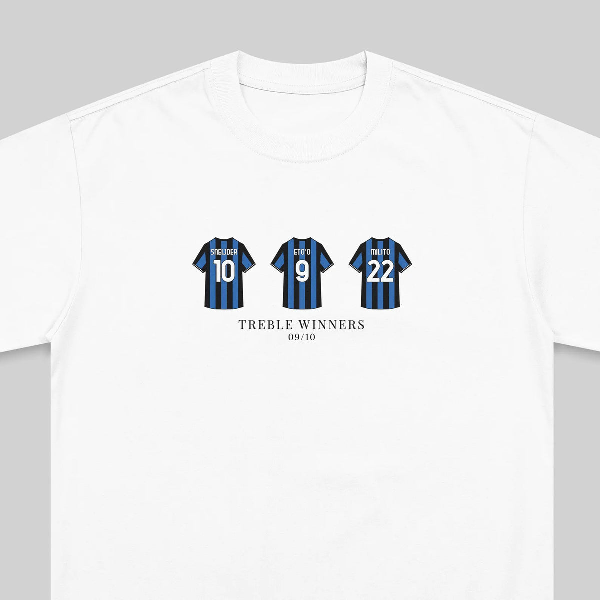 A white crewneck t-shirt featuring a graphic print of three blue and black striped soccer jerseys with the numbers 10, 9, and 22, and the text 'TREBLE WINNERS 09/10' printed below.