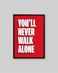 A framed motivational poster with the text 'YOU'LL NEVER WALK ALONE' in bold white letters on a bright red background, shown against a light gray wall.