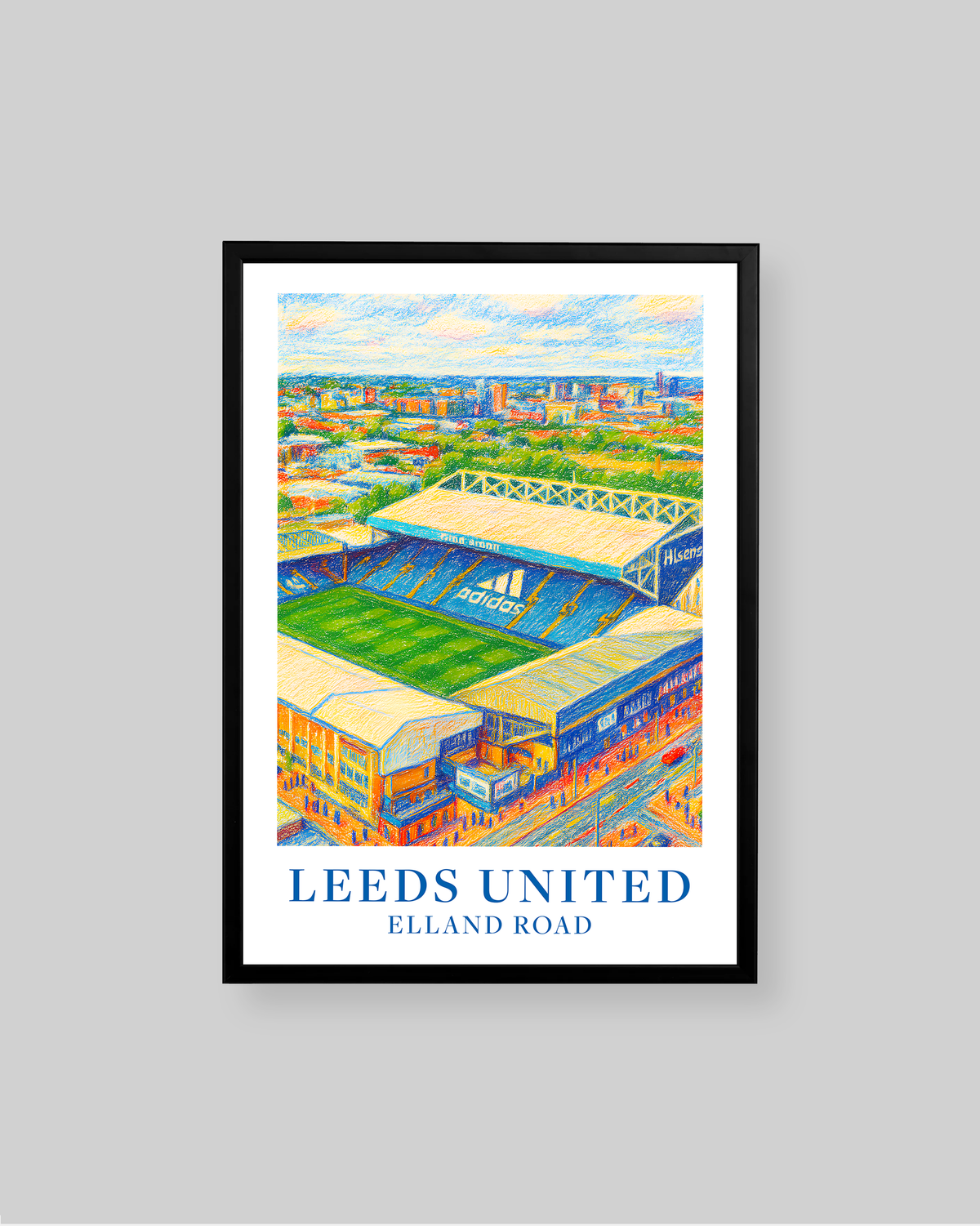 A framed art print of a Leeds United football stadium illustration, featuring the text 'LEEDS UNITED' and 'ELLAND ROAD' at the bottom, displayed against a solid gray background.