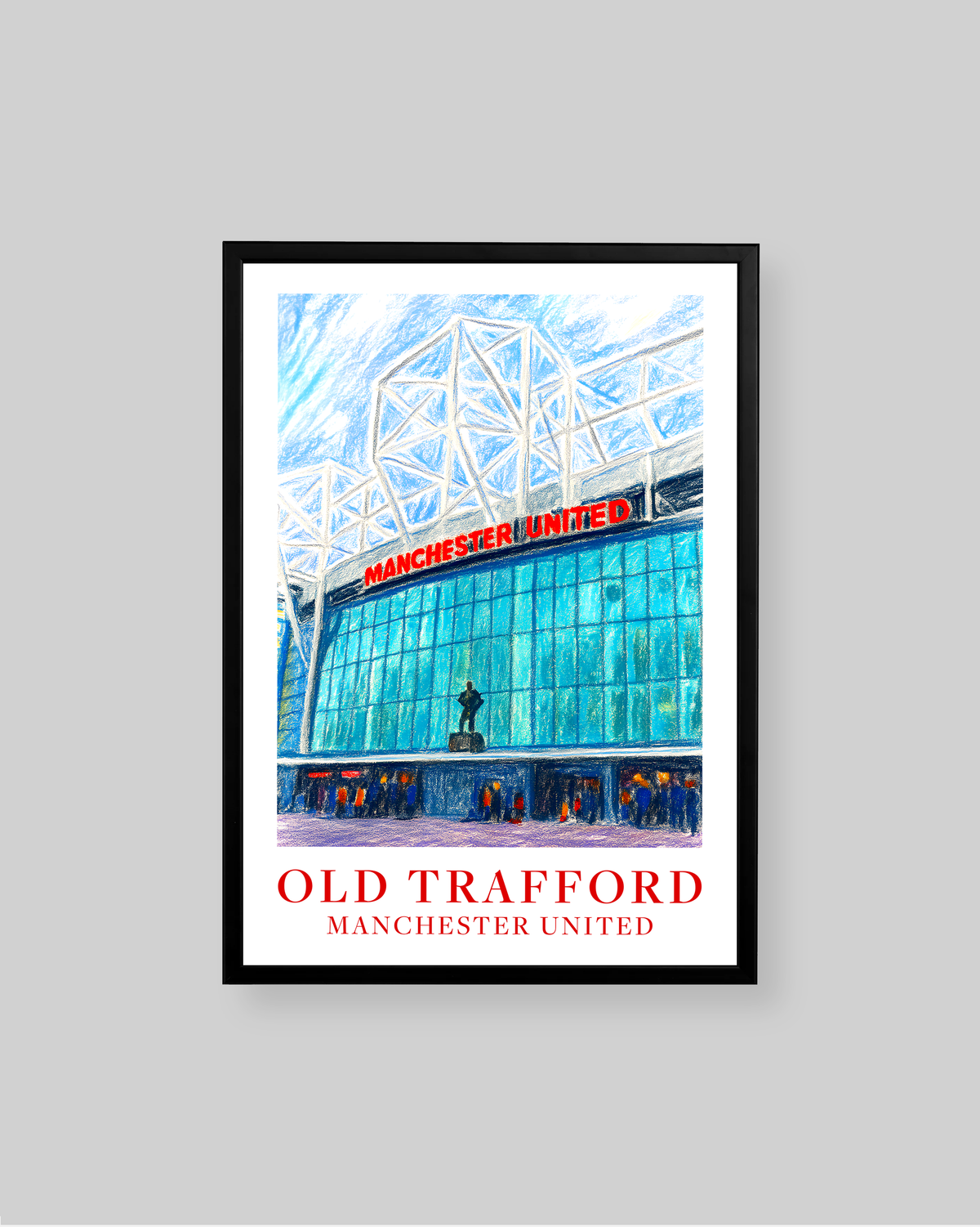 A framed art print of Old Trafford stadium in Manchester United, featuring a vibrant blue and white architectural illustration with red text, displayed on a neutral gray background.